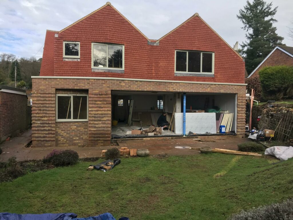 A house under construction with red brickwork in progress by Fost & Co.